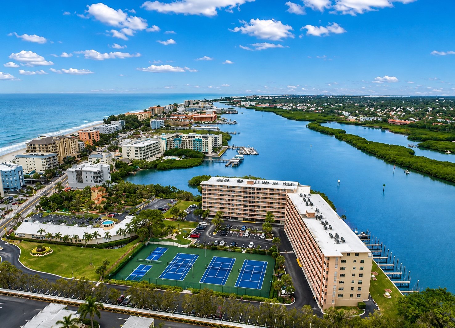 Aerial view of Indian Shores: the Gulf of Mexico along the barrier island, and the Bay Shores building with its tennis courts and docks on the Intracoastal