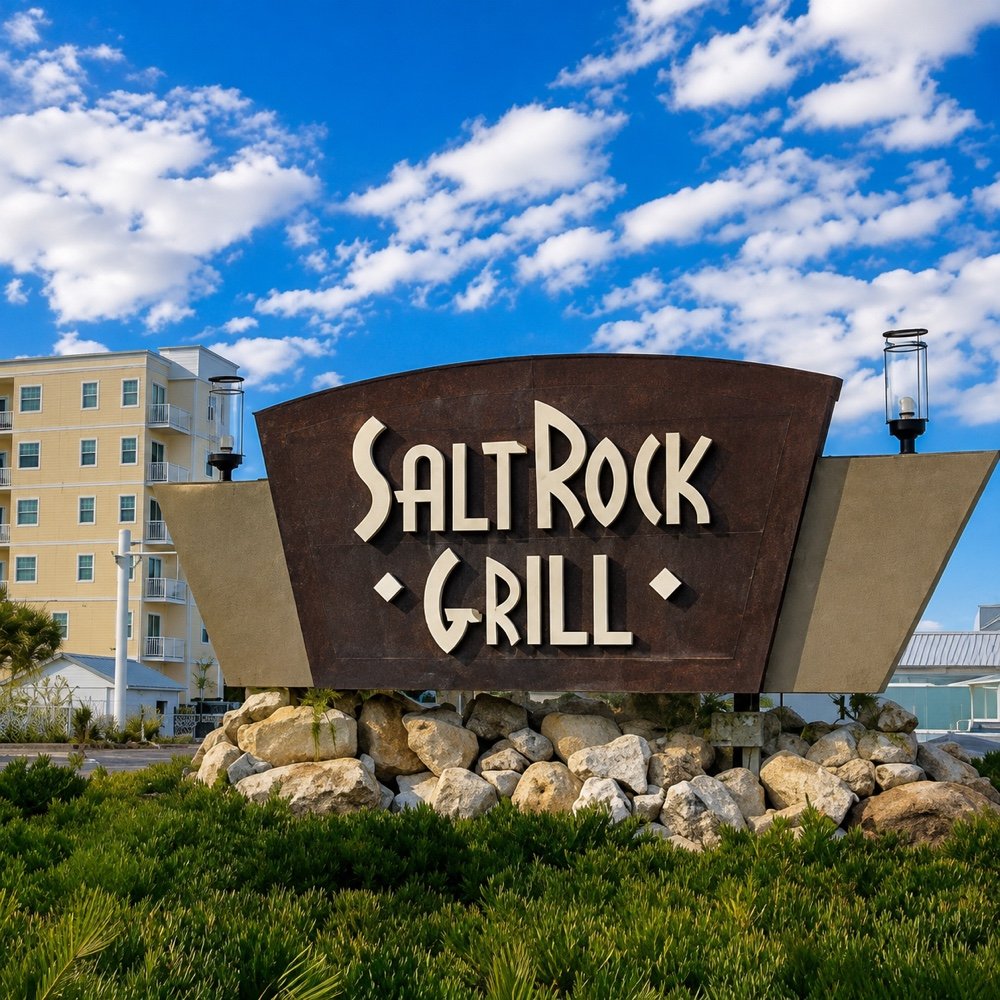 The Salt Rock Grill sign on Gulf Blvd, set on rocks beneath a blue sky