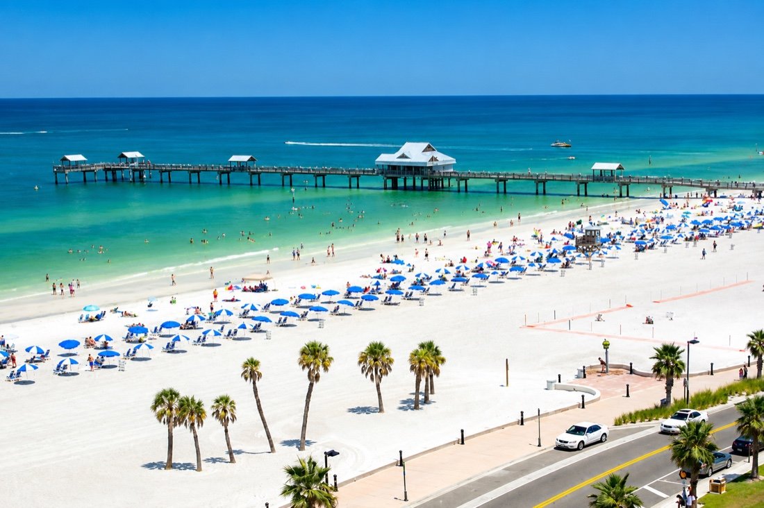 Clearwater Beach with Pier 60, rows of blue umbrellas and turquoise water