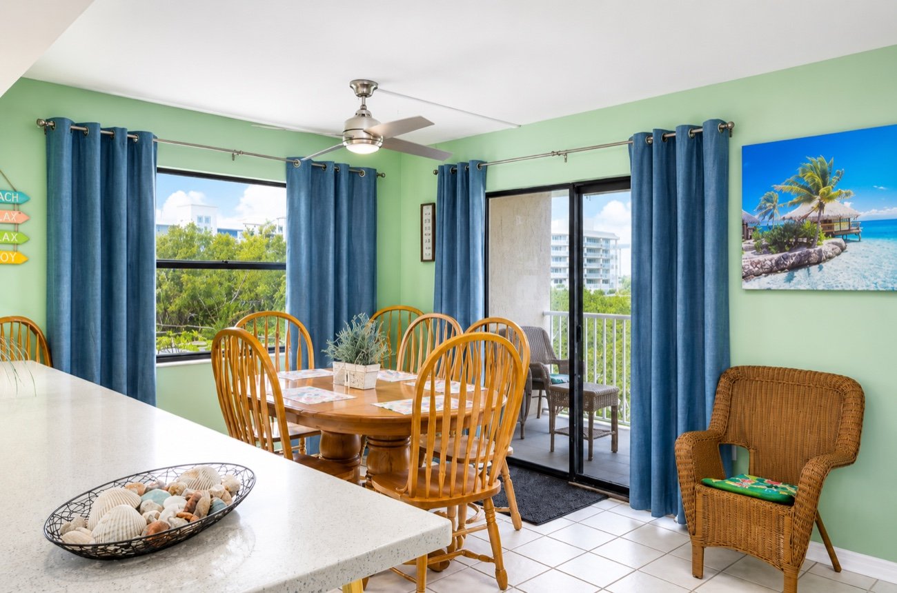 The dining room, with a round table for six and sliding doors onto the balcony