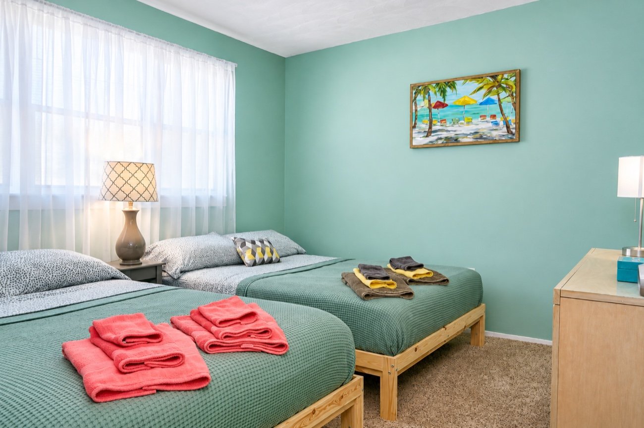Bedroom two, with two double beds and towels folded on each