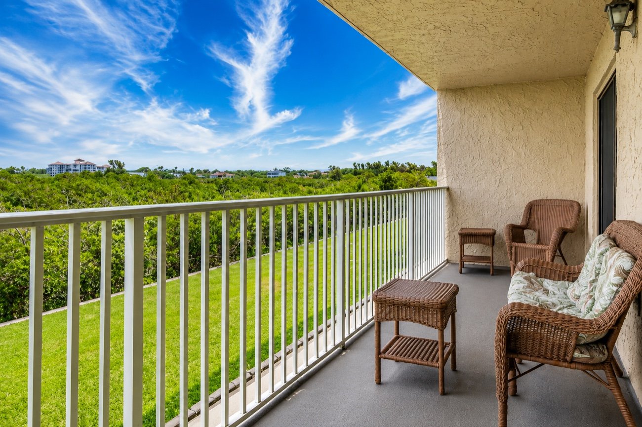 The private balcony with wicker chairs and a side table